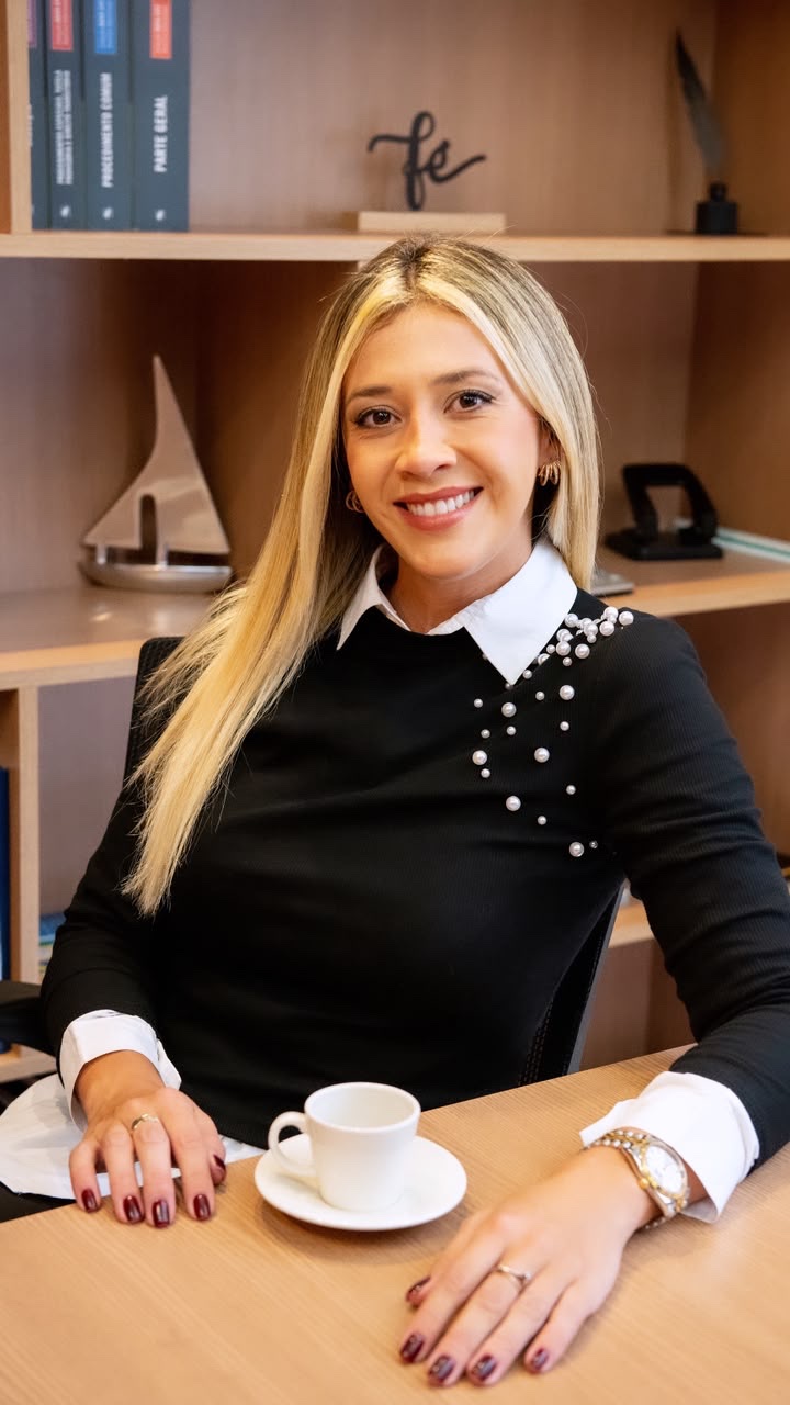 Caroline sorrindo à mesa de seu escritório